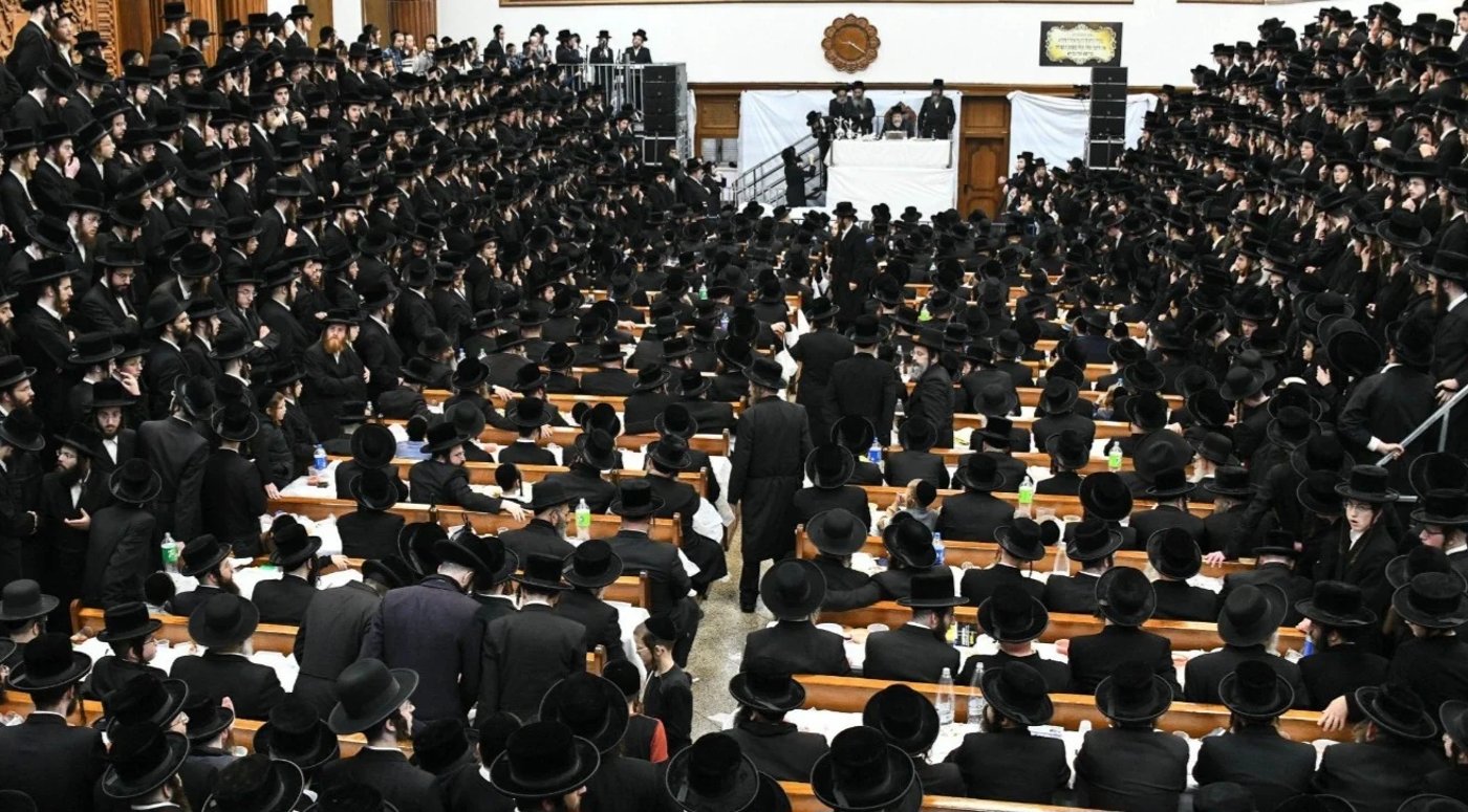 הרבי מרחמסטריווקא בטיש בביהמ"ד, השעון הגדול מתחתיו