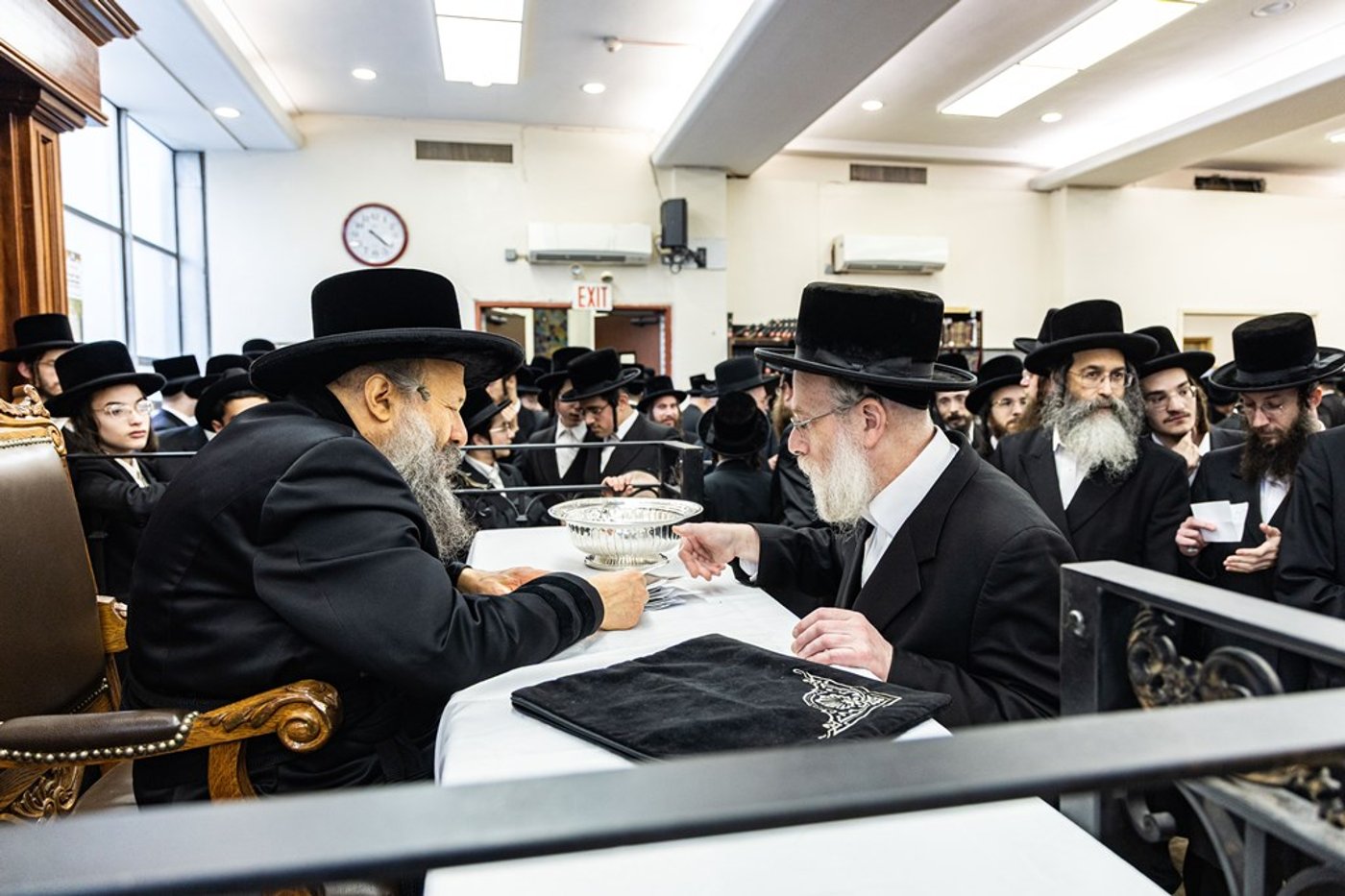 חסידי באבוב 45 נותנים קוויטלעך לרבם לפני המסע לצאנז