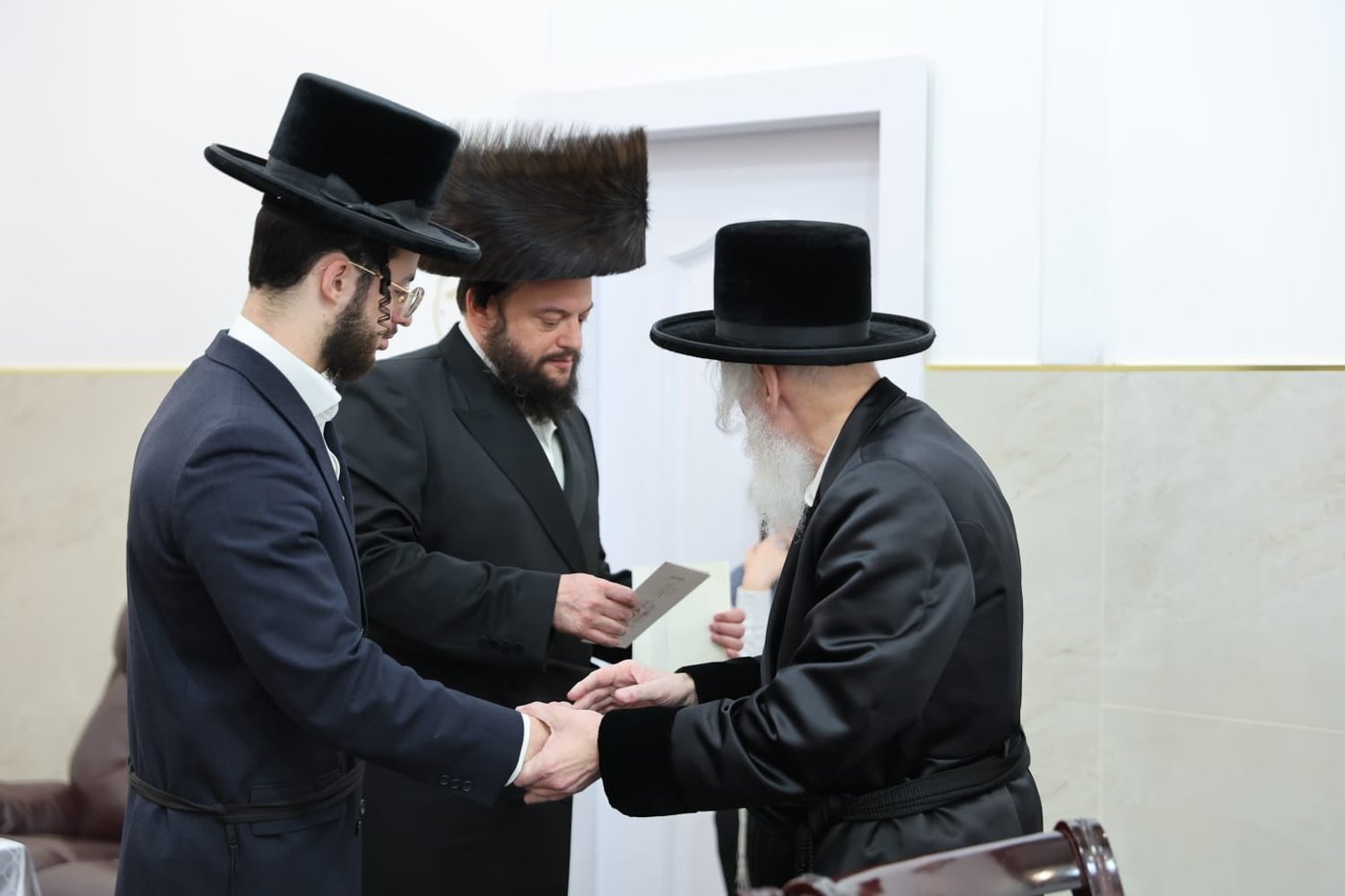 האדמו"ר מויזניץ בלחיים לאחר הנחת תפילין לבנו של ר' ישראל וייס