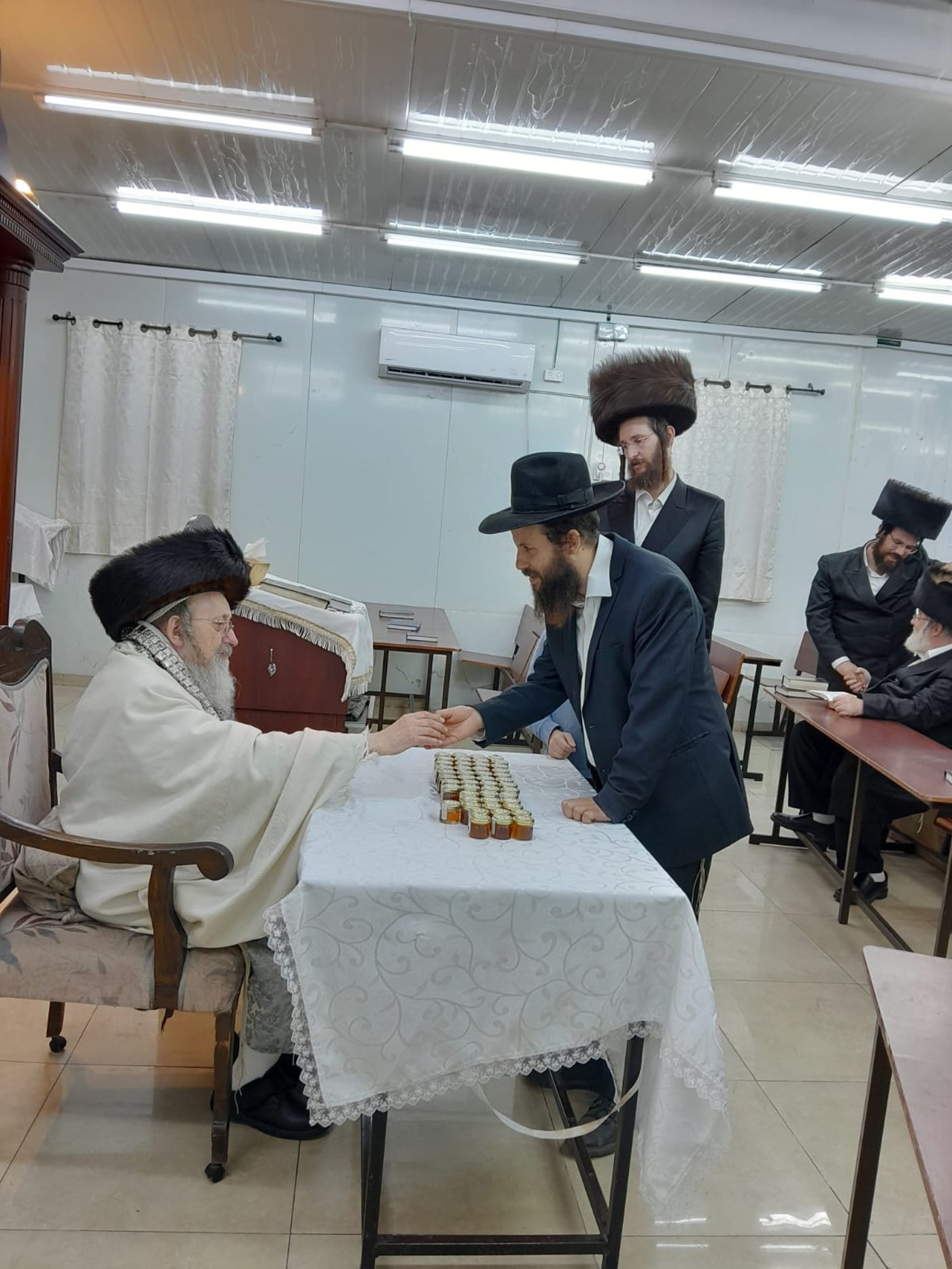 האדמו"ר מקאליש בחלוקת צנצנות דבש לאחר סליחות