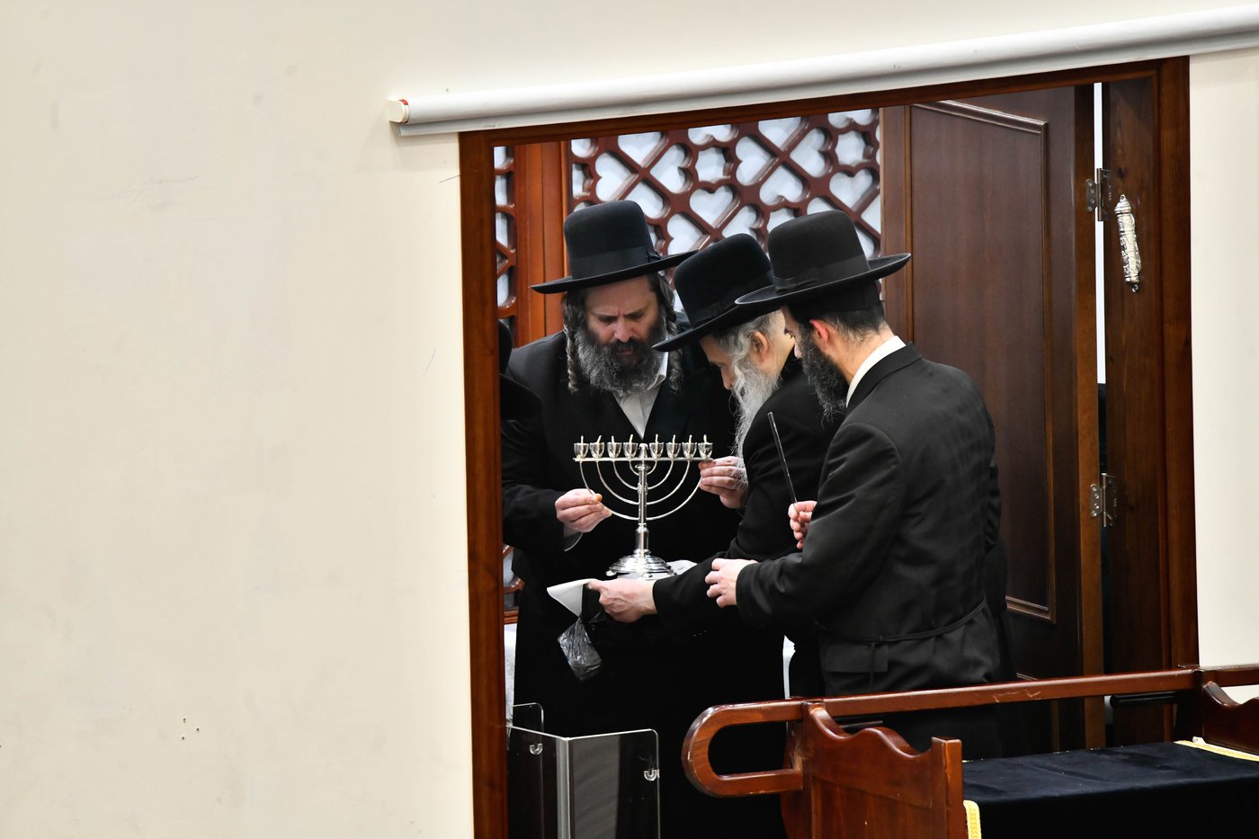 מוטי בבצ'יק מסדר את החנוכייה של האדמו"ר מגור