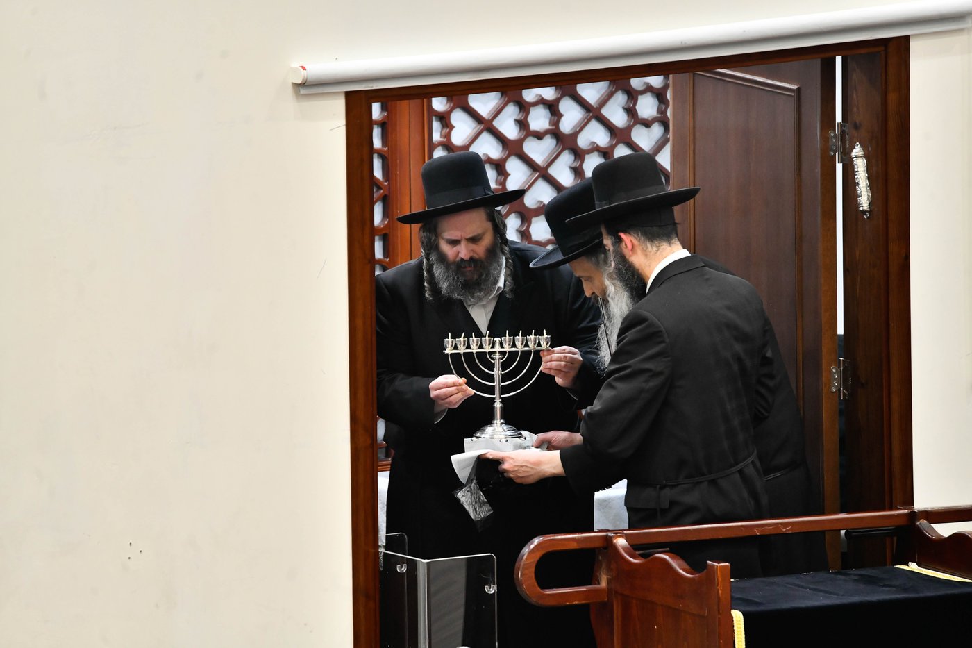 מוטי בבצ'יק מסדר את החנוכייה של האדמו"ר מגור