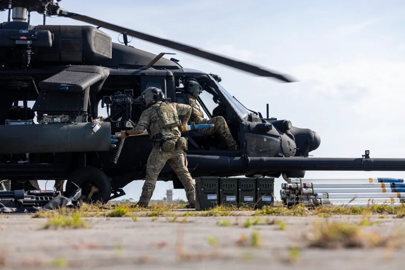 חייל צבא ארה״ב טוען רקטות למסוק MH-60 Black Hawk