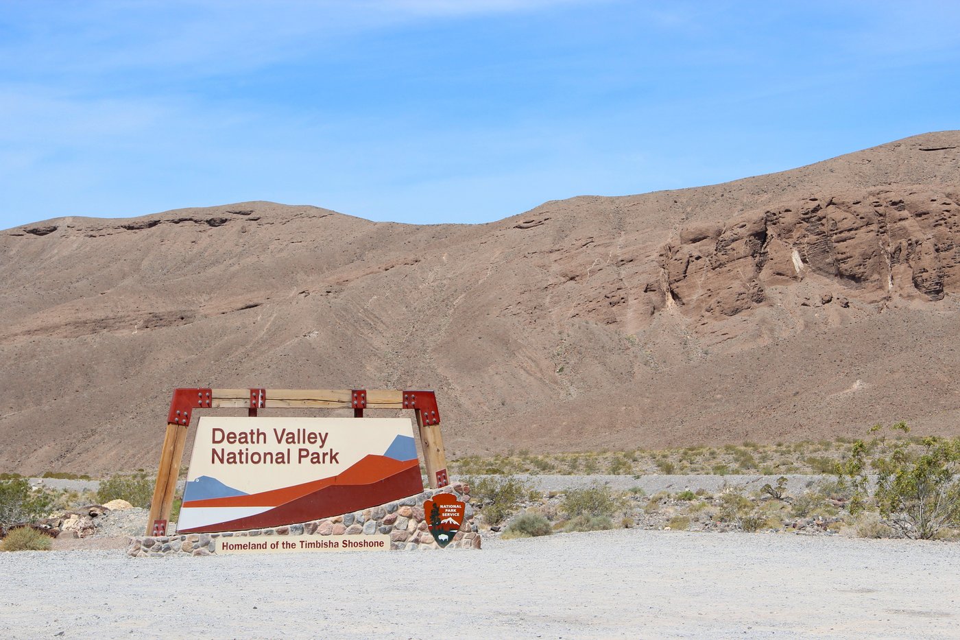שלט הכניסה לפארק הלאומי עמק המוות – על השלט כתוב: "פארק לאומי עמק המוות" ובקו קטן יותר בתחתית: "מולדת שבט הטימבישה שושונה".