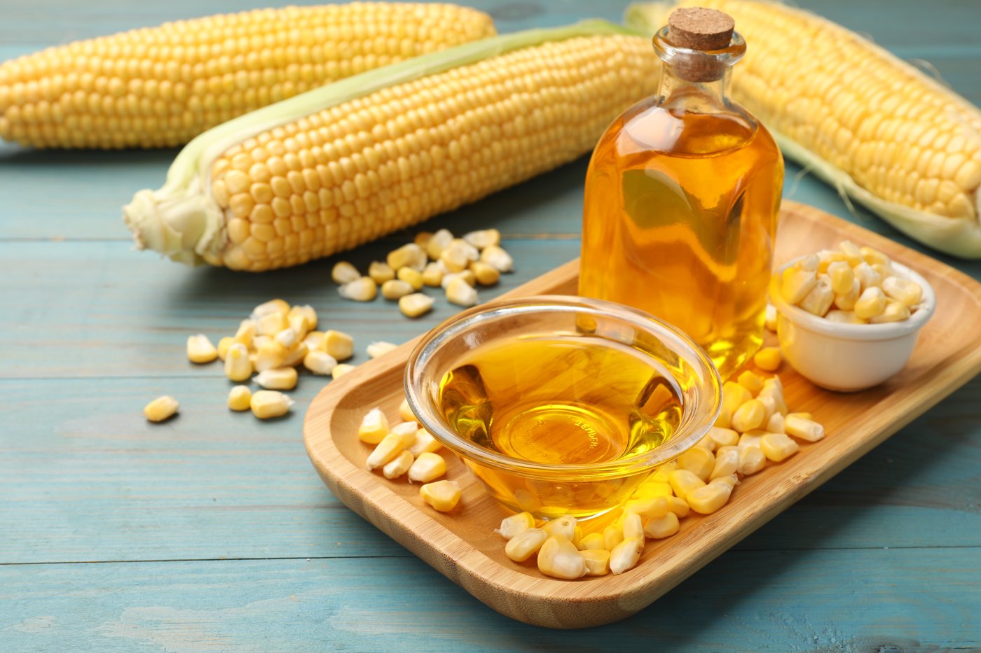 קלחי תירס לצד שמן תירס וגרגירים