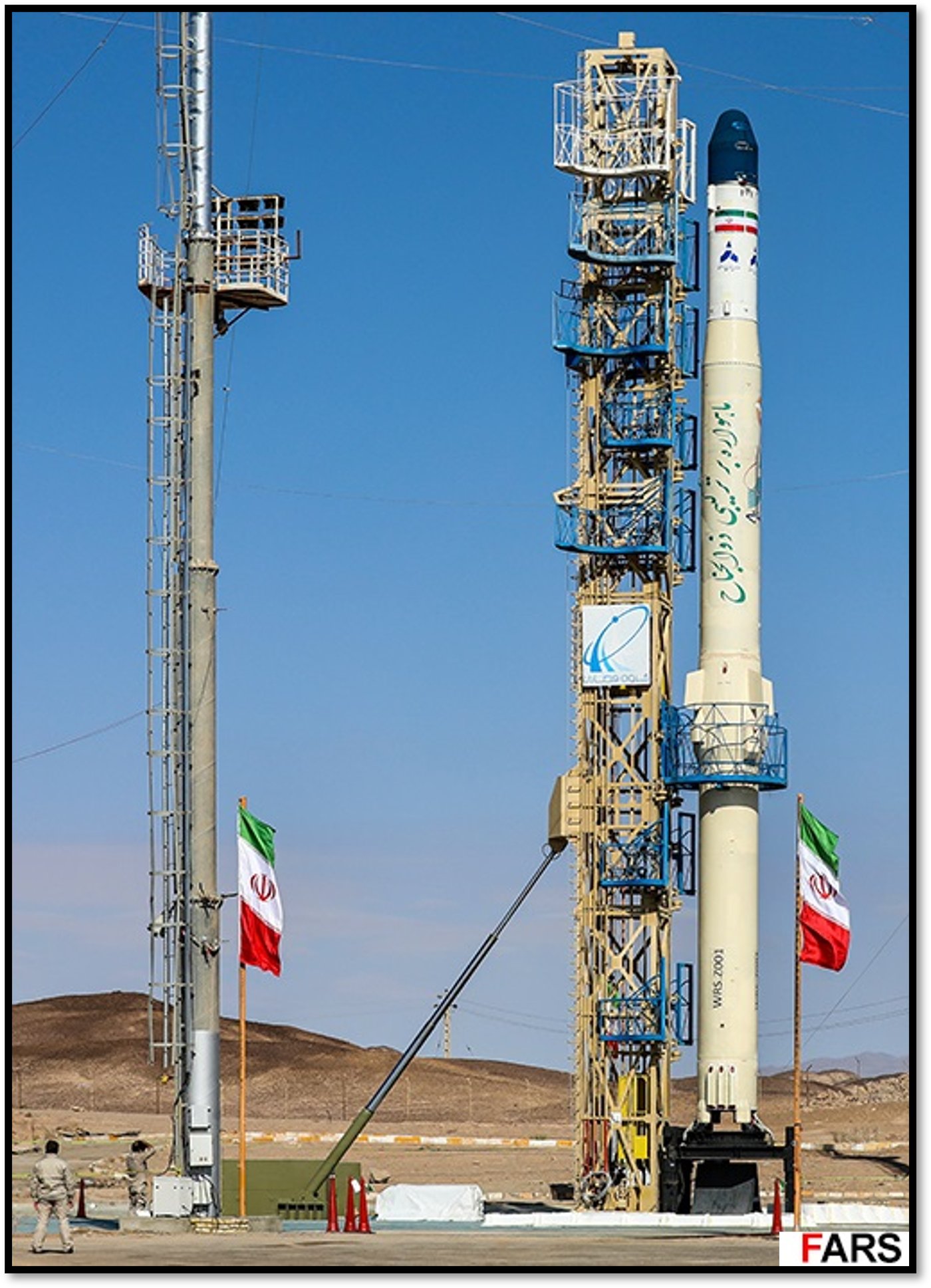 משגר הלוויינים האיראני "זולג'נאח" (Zuljanah) על כנה השיגור במרכז החלל בסמנאן, לצד מגדל שירות ודגלי איראן.