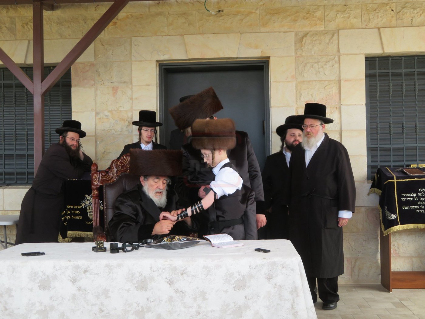 האדמו"ר מויז'ניץ בהנחת תפילין לנכדו משה יהושע הגר
