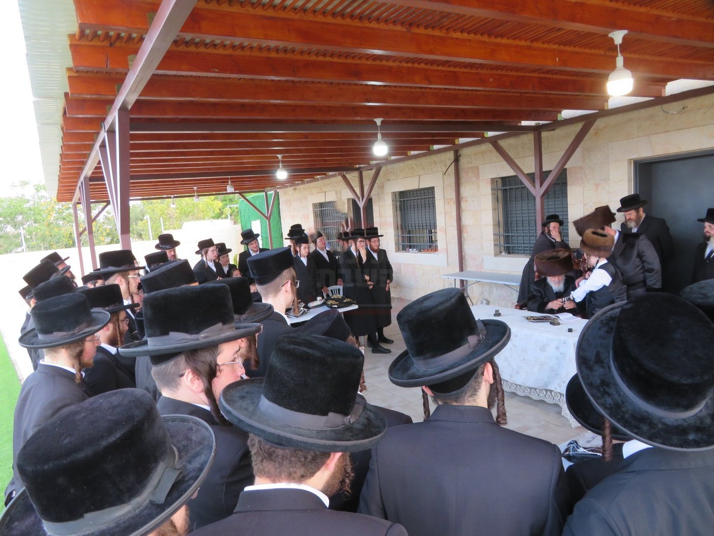 האדמו"ר מויז'ניץ בהנחת תפילין לנכדו משה יהושע הגר