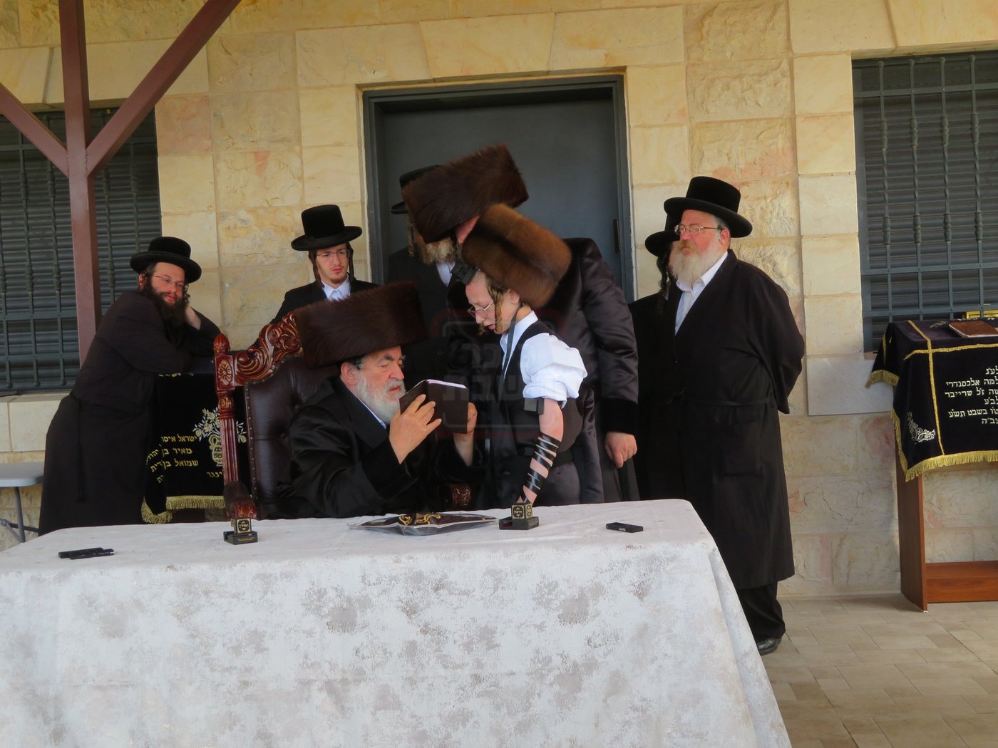 האדמו"ר מויז'ניץ בהנחת תפילין לנכדו משה יהושע הגר