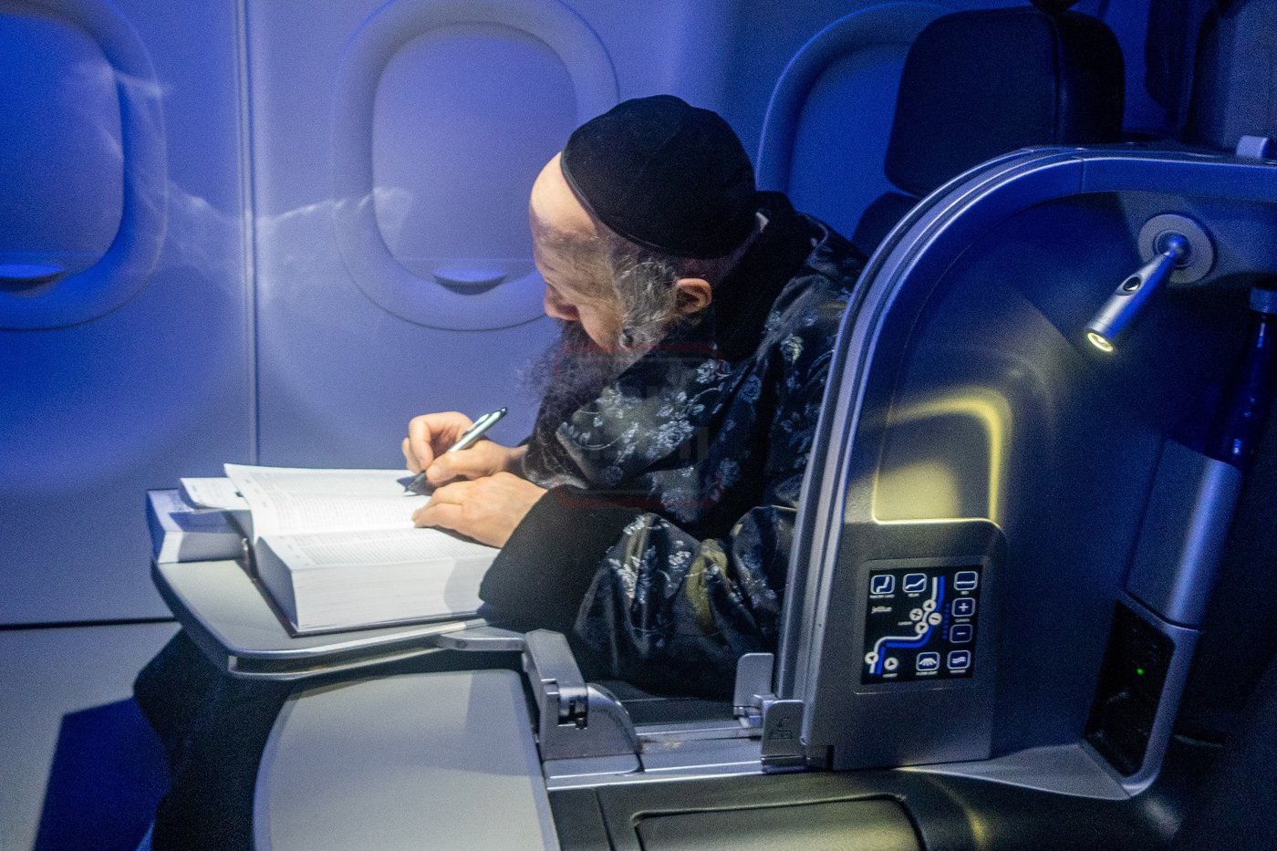האדמו"ר מבאבוב 45 הוגה בתורה במטוס