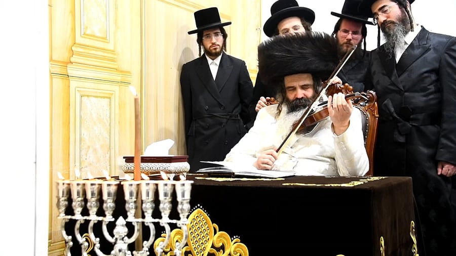 האדמו"ר מזוטשקא מנגן בכינור בסיום מעמד ההדלקה
