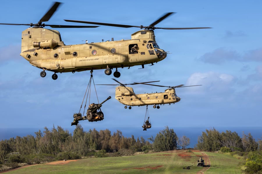 שני מסוקי צ'ינוק מדגם CH-47 , מטילים תותחים מסוג M119 במהלך פעולות תקיפה אוויריות באזור האימונים של קהוקו , הוואי,