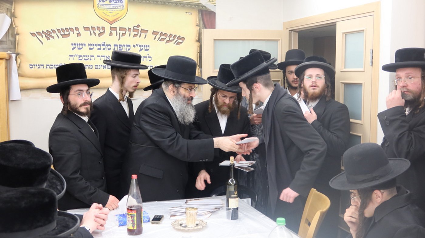 הגה"צ רבי צבי מאיר זילברברג בחלוקת שוברי השטריימלעך לחתנים