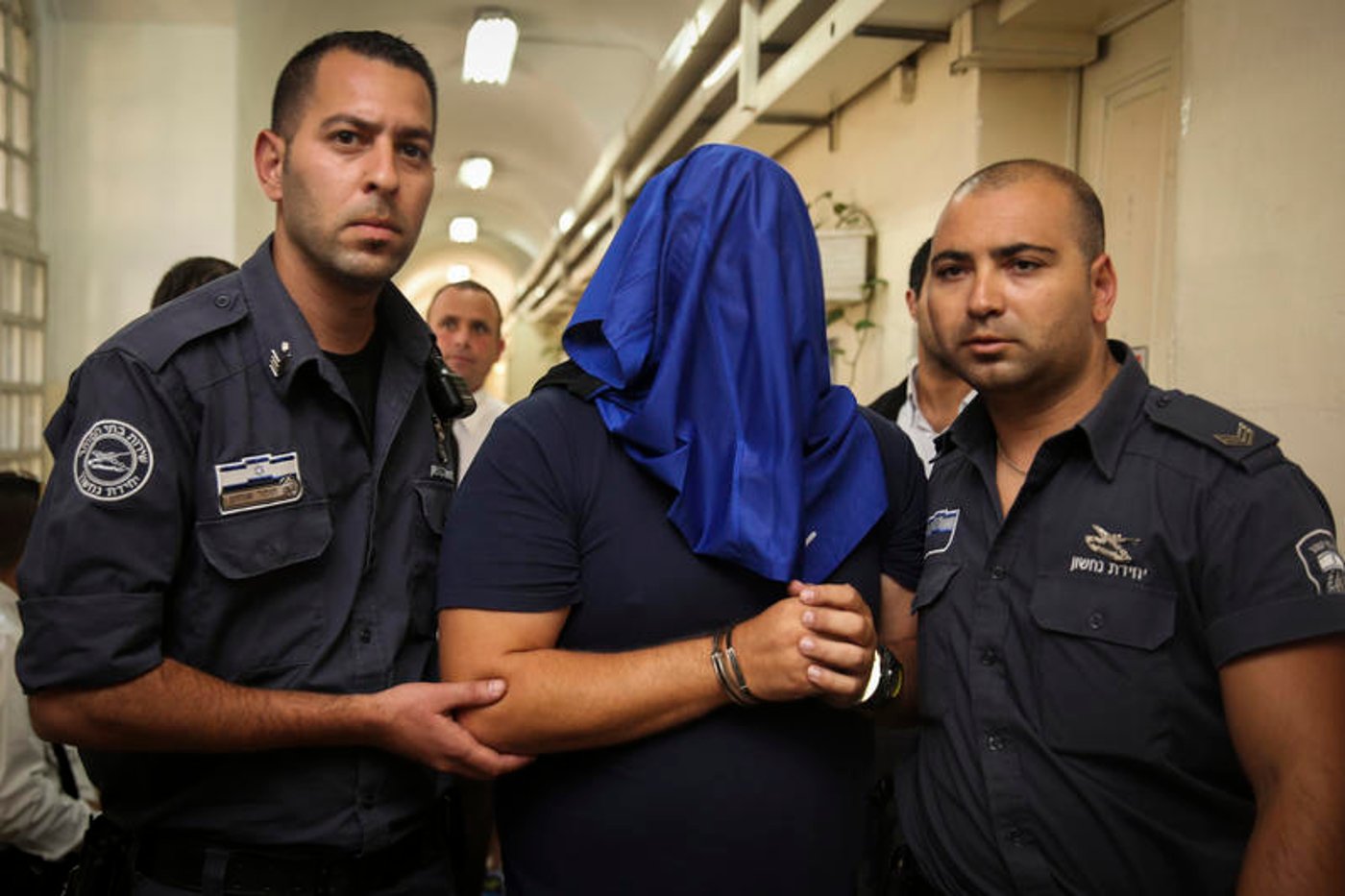 אלי מוסלי מובל לבית המשפט בזמן מעצרו (לשוטרים אין קשר לכתבה)