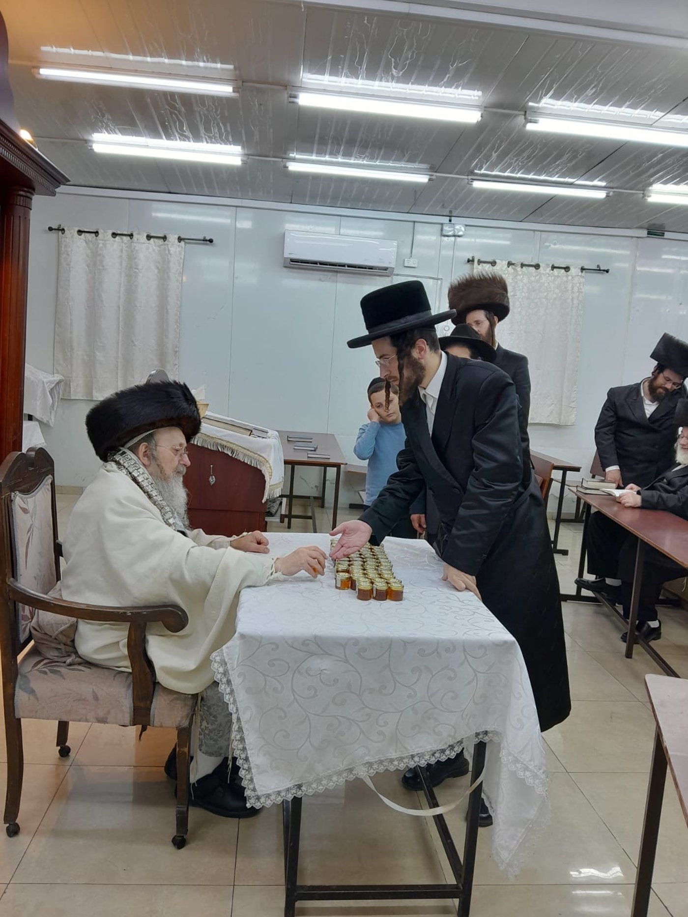 האדמו"ר מקאליש בחלוקת צנצנות דבש לאחר סליחות
