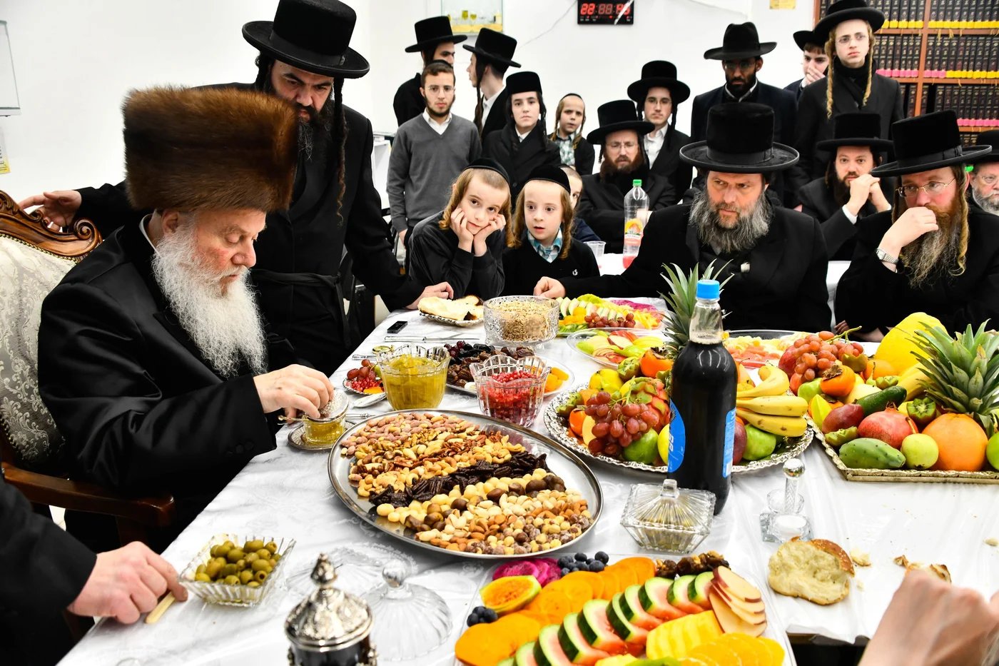 רבי חיים דוב הלפרין זצ"ל, יושב לצד אביו שליט"א בטיש ט"ו בשבט