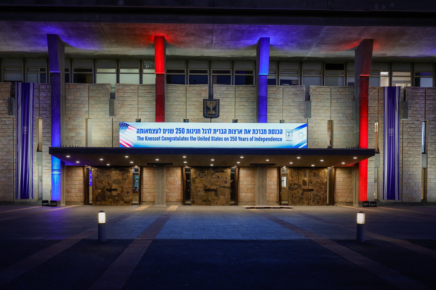 משכן הכנסת מואר בצבעים כחול, אדום ולבן - צבעי דגל ארה״ב