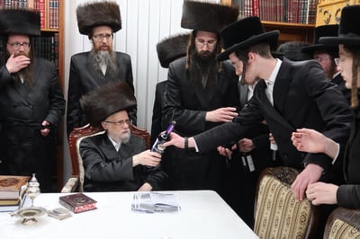 האדמו"ר מסערט ויז'ניץ בחלוקת יין לארבע כוסות למצטייני הישיבה 