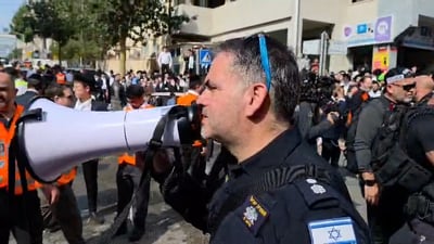 המוני סקרנים בזירה בעיר החרדית; כך השוטר מנסה לפנות את הרחוב