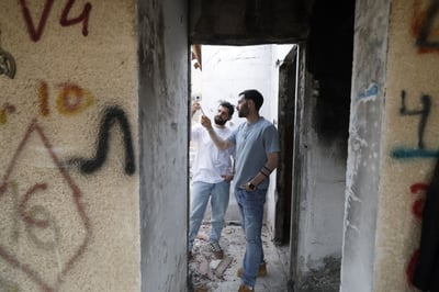 התאומים ברמן עם המזוזה ששרדה בבית השרוף