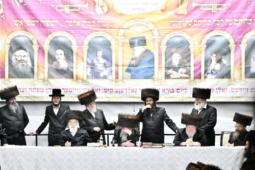 הרבי מביאלה ערך טיש אושפיזין כשדמויות הקודש של אדמו"רי החצר משקיפות מאחור