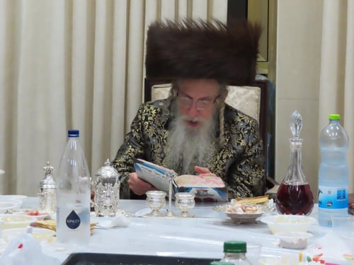 על יד סטנדר ענק בגרם המדרגות: כך שרף האדמו"ר ממעליץ את הפתילות של חנוכה